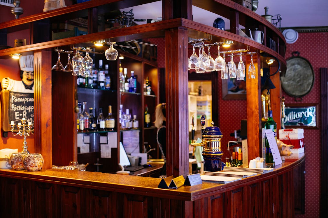 Balcão de bar com taças penduradas e torneira de chope