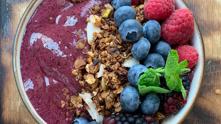 Tigela de açaí com granola, mirtilo, framboesa e folhas de hortelã